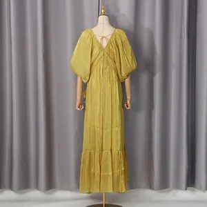 Vue arrière d'une robe de vacances jaune à col en V avec volants et manches bouffantes