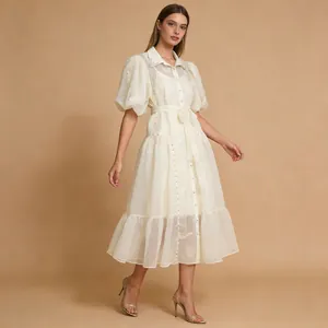 Vista completa de un vestido crema con mangas abullonadas, cuello de solapa y cinturón