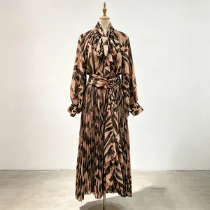 Elegant pleated skirt set with abstract pattern and pussy bow blouse on mannequin.