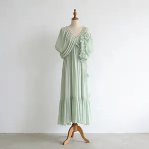 Détail de la robe vert clair à col en V avec fleurs 3D romantiques sur un mannequin