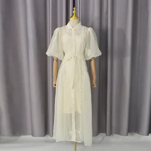 Vista detallada de un vestido blanco roto con mangas abullonadas, bordado y cinturón