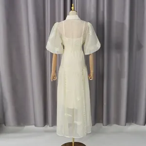 Vista trasera de un vestido largo bordado en crema con mangas abullonadas en maniquí