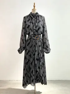 Elegant black and white geometric print two-piece set with tie neck and pleated skirt