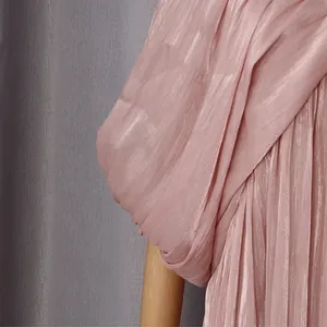 Gros plan sur la manche chauve-souris plissée rose d'une robe longue de style vacances