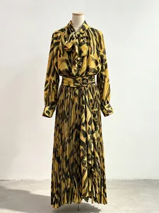 Elegant pleated maxi skirt and long-sleeve bow-tie blouse set in yellow abstract print