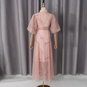 Vista trasera de un elegante vestido largo rosa con mangas abullonadas y bordados de hojas