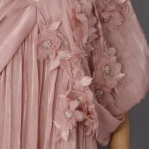 Détail macro de l'élégante robe rose avec appliques florales 3D et perles fines