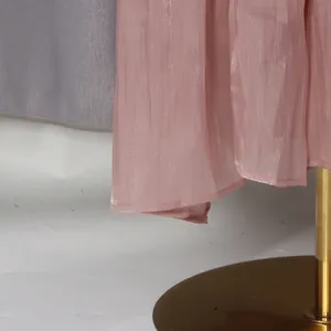 Détail du tissu rose scintillant et de l'ourlet d'une robe longue de vacances romantique