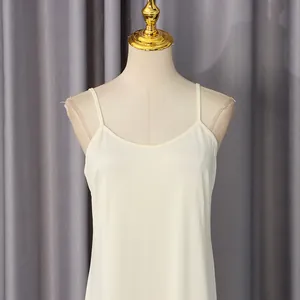 Primer plano de un vestido lencero sin mangas color crema en un torso de maniquí
