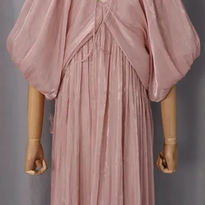 Vue détaillée d'une robe de vacances plissée rose en tissu scintillant avec manches chauve-souris