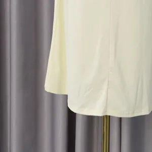 Primer plano del dobladillo liso y la tela amarillo pálido del vestido de estilo dulce