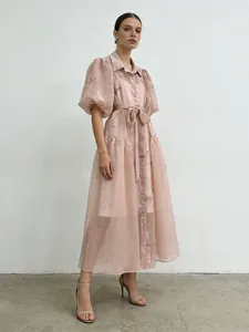 Elegante vestido largo bordado rosa con mangas abullonate, solapa y lazo en cintura.