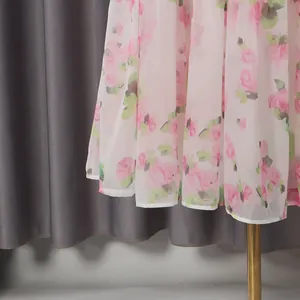 Close-up of pink floral print dress showing delicate fabric texture and hem detail.