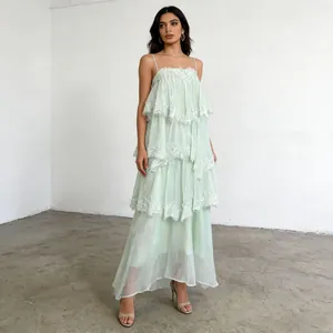 Elegant mint green tiered maxi dress with delicate lace trim and spaghetti straps