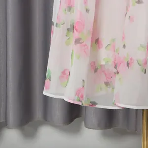 Detailed close-up showing the pink floral print and sheer fabric of the dress hem