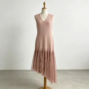 Detail of sleeveless V-neck dress featuring elegant asymmetrical pleated mesh hem in pink.