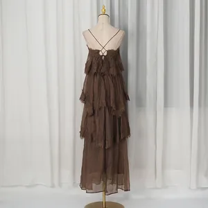Back view of brown tiered maxi dress with delicate lace trim and cross-strap detail