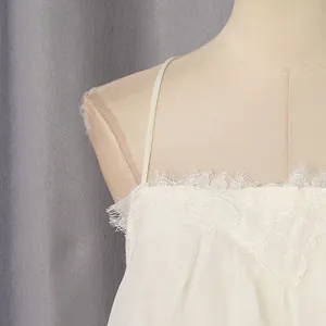 Close-up of delicate lace trim and thin strap on a white sweet style dress