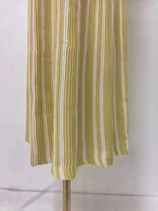 Close-up showing the yellow and white vertical striped ribbed texture of the pleated dress