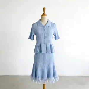 Detailed view of light blue knitted two-piece set with polo collar and lace trim.