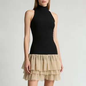 Detail view of a sleeveless mock neck dress with a tiered champagne ruffled skirt.