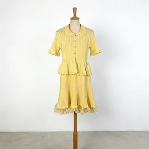 Front view of yellow knit two-piece set with POLO collar top and lace-trim A-line skirt.