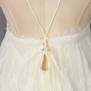 Detailed view of the intricate lace trim and back lacing on the cream suspender dress