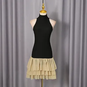 Detail of sleeveless bodycon dress with champagne tiered ruffle hem and high neck.