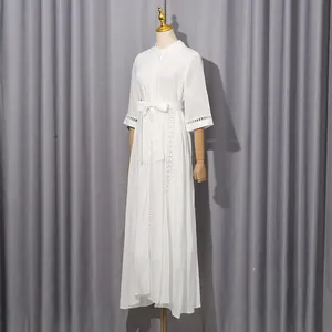 Detail view of a white French vintage maxi dress with hollow-out lace and waist tie