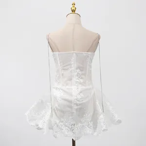 Vue détaillée du dos d'une robe caraco élégante en dentelle blanche avec broderie