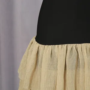 Close-up showing the transition from the black bodice to the ruffled beige mesh skirt