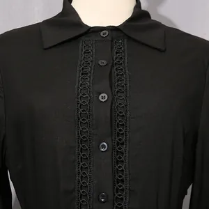 Close-up of hollow-out lace trim and buttons on a black French vintage style dress