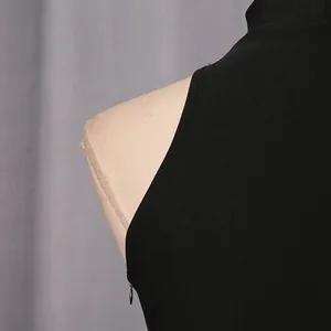 Close-up detail view of a black sleeveless stand collar dress showing hidden side zipper