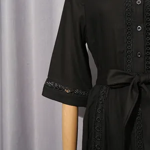 Close-up of black French vintage dress with hollow lace embroidery and tie-waist