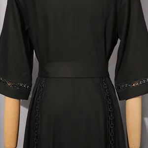 Detail view of a black French retro dress showing the belted waist and lace sleeve work