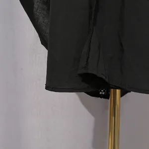 Macro view of black retro palace style dress hem highlighting fine fabric texture