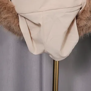 Close-up detail of beige fabric and fluffy brown faux fur trim of a sexy three-piece set