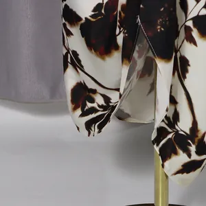 Macro detail view of elegant floral rose print on a silky white flowy dress fabric