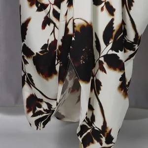 Detailed macro view showing the dark floral pattern on white fabric of the casual dress