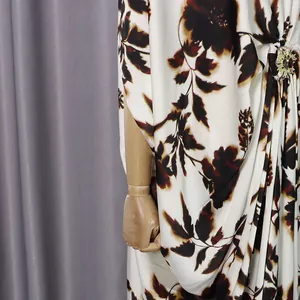 Close-up of loose floral dress with an elegant gold rhinestone metal buckle detail.