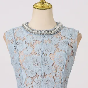 Detailweergave van de elegante parel- en stras-halslijn op een blauwe kanten jurk