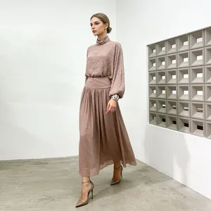 Detail view of an elegant dusty rose sequined two-piece set with a high neck and A-line skirt.