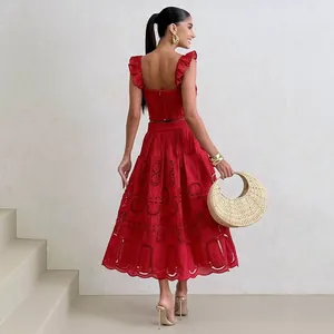 Elegante vista posteriore del set vacanza rosso due pezzi con top e gonna midi
