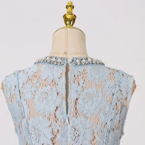 Detail van de achterkant van een blauwe kanten jurk met parels en verborgen rits