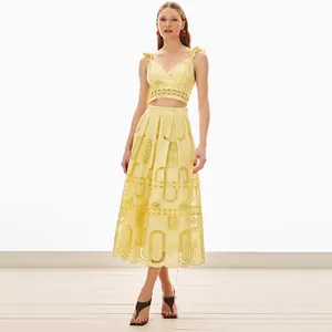 Elegante completo due pezzi in pizzo giallo con crop top a volant e gonna midi a vita alta
