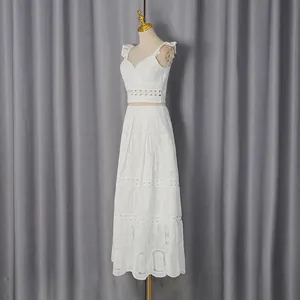 Dettaglio completo di due pezzi in pizzo bianco con top scollo a V e gonna lunga