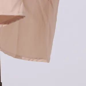 Detailopname van de hoogwaardige zoomstiksels van een lichtroze mouwloze midi-jurk