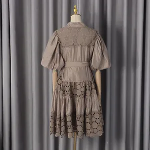 Detail view of a taupe French puff sleeve mini dress with intricate hollow-out floral lace