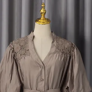 Detail of taupe V-neck dress featuring floral lace shoulders and puff sleeves