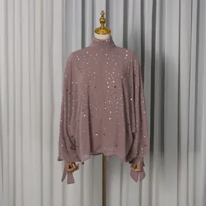 Detailed view of dusty rose high-neck top featuring sparkling rhinestone embellishments.